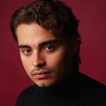 moody black and red headshot of director Elias Hinojosa