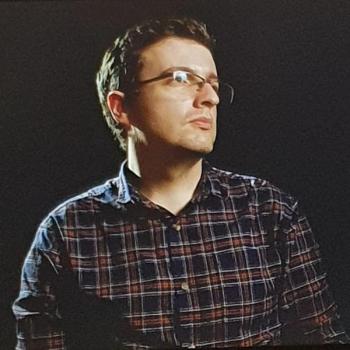 FIlmmaker Shane Anderson looking to the right, on a black background.