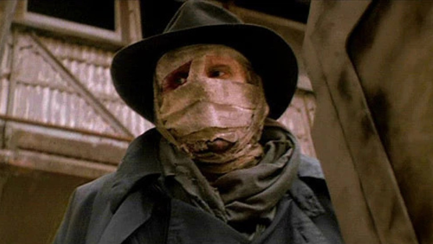 Darkman with face covering and hat looks on