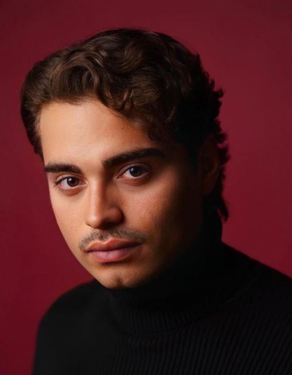 moody black and red headshot of director Elias Hinojosa