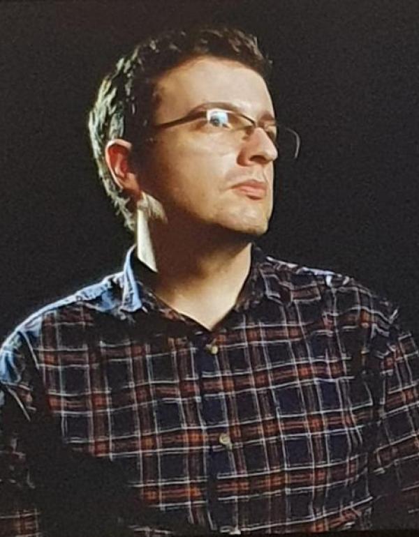 FIlmmaker Shane Anderson looking to the right, on a black background.