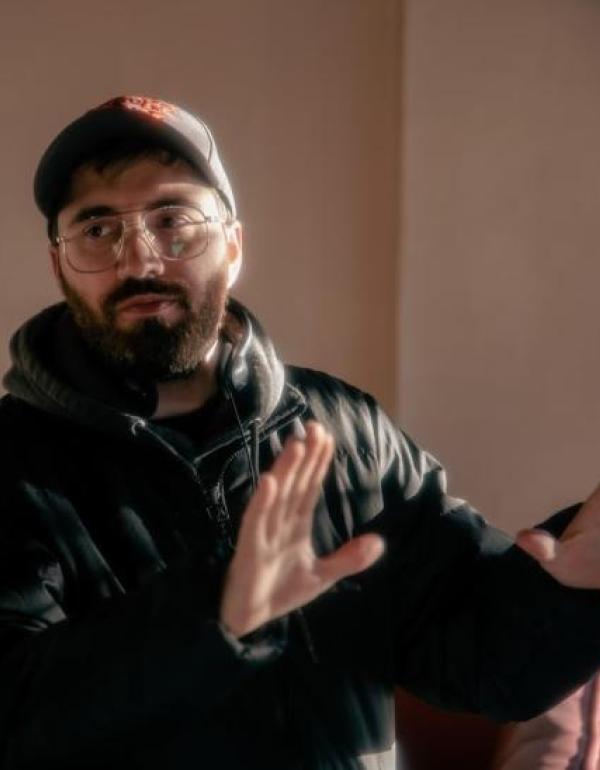 A man uses his hands to frame a shot on set.